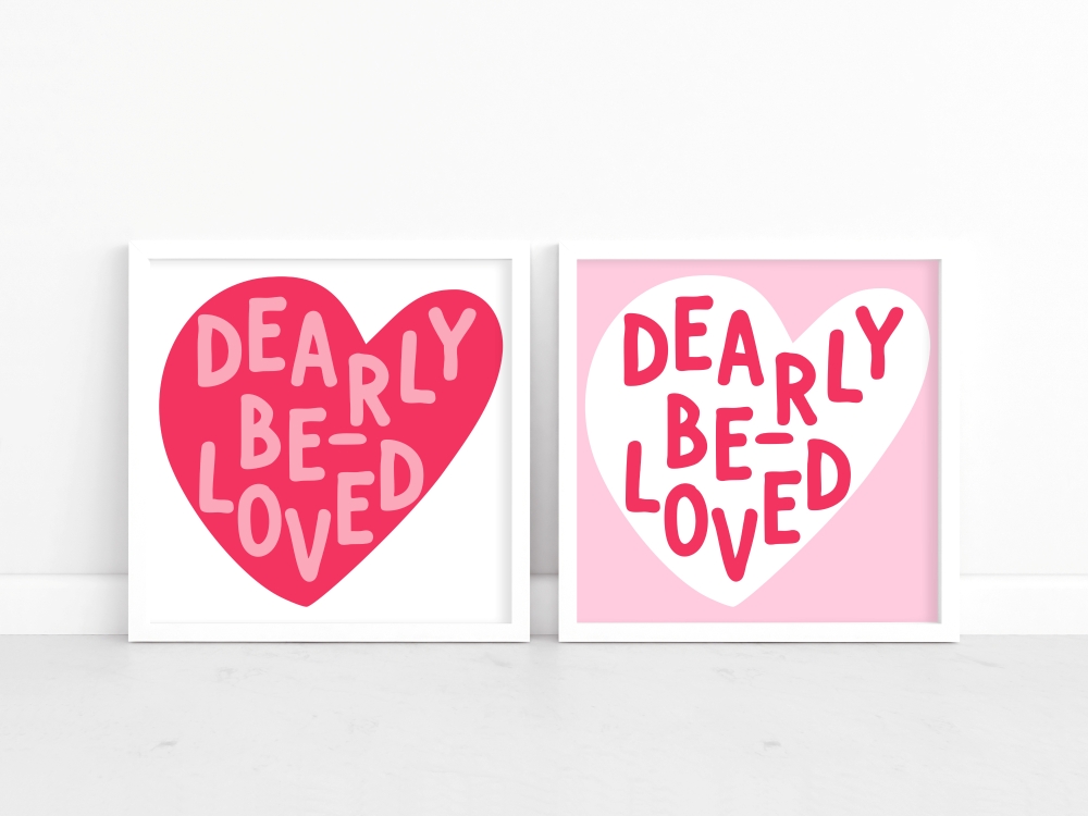 A mockup of two framed art prints with the phrase 'Dearly Beloved' inside a heart. The left version shows a pink heart on a white background, while the right version shows a white heart on a pink background.