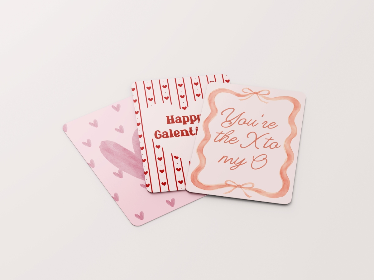 A group of three pink and red Galentine's cards fanned out, featuring watercolor hearts, red stripes, and a wavy ribbon border.