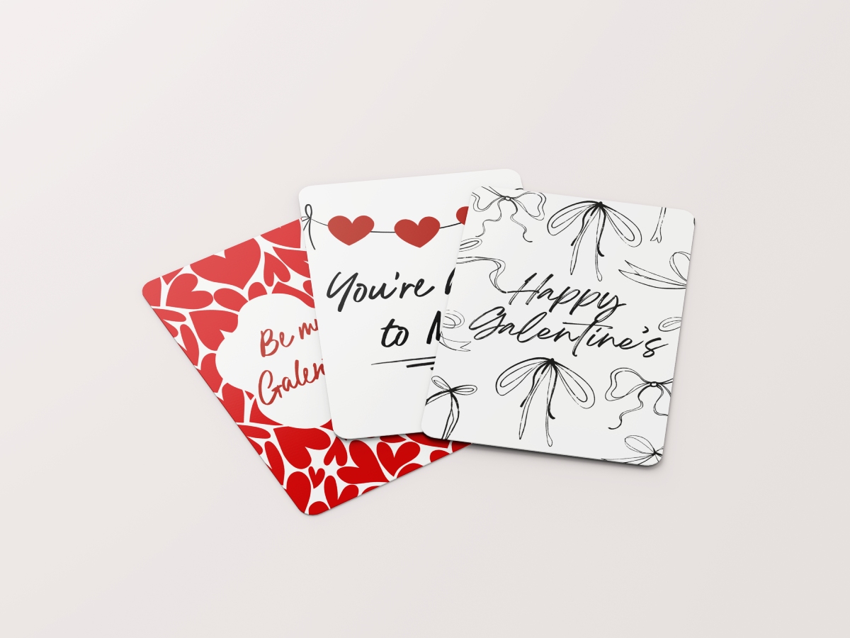 A group of three Galentine's cards fanned out, featuring a red heart pattern, a heart bunting design, and a black line-art bow pattern.