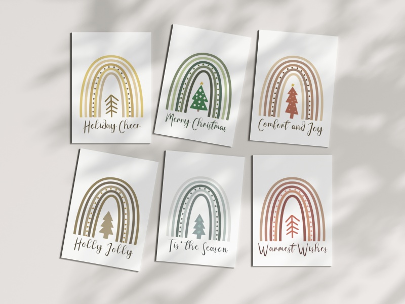 Boho Christmas cards with rainbow arches, Christmas trees, and muted colours.