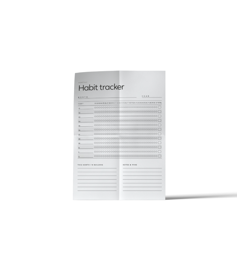 A folded printable monthly habit tracker with twelve habit rows, daily tracking circles and sections for notes and wins.